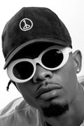 Andre Blunt black cap with embroidered wheel of peace, worn front