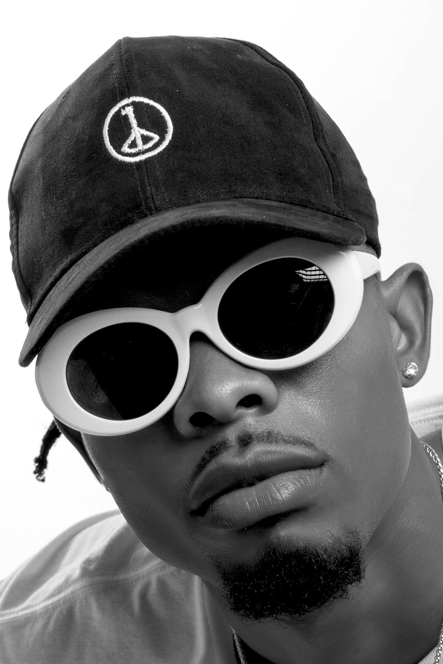 Andre Blunt black cap with embroidered wheel of peace, worn front