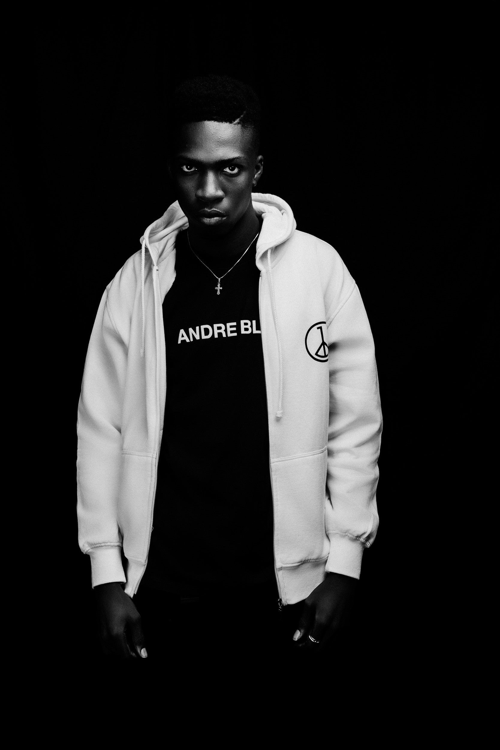 Andre Blunt off-white zip-up hoodie worn open over a black tee, black and white