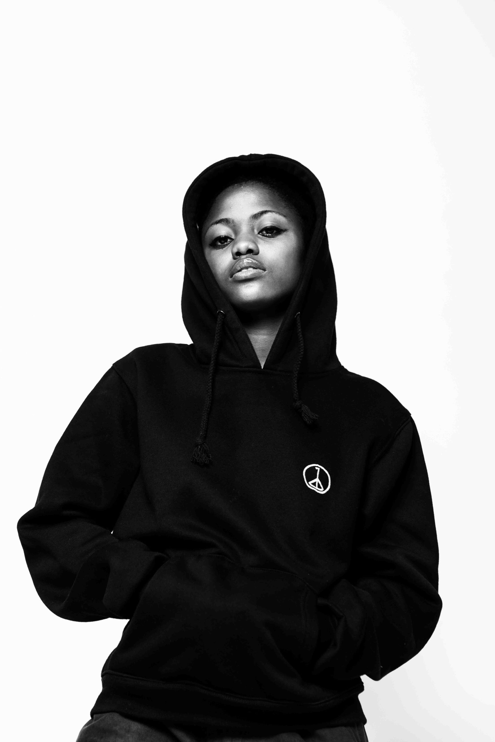 Andre Blunt black pullover hoodie with embroidered wheel of peace, studio front