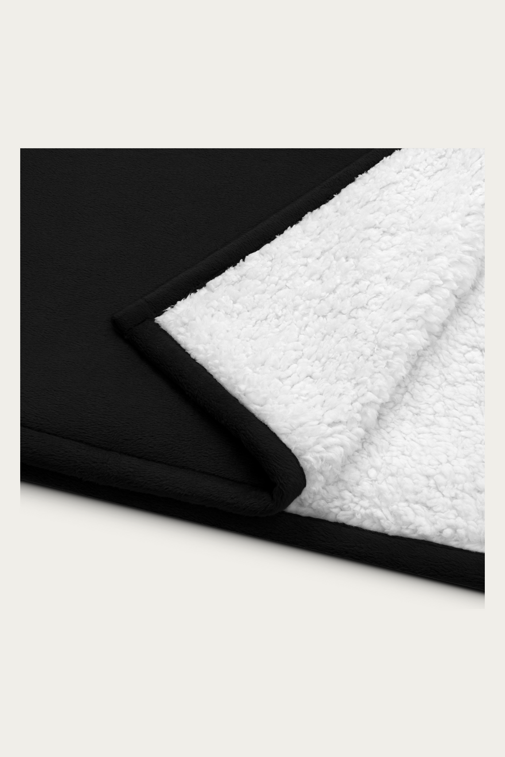 Sherpa Blanket, Black by Andre Blunt, folded corner showing the sherpa reverse, on a Cloud White ground